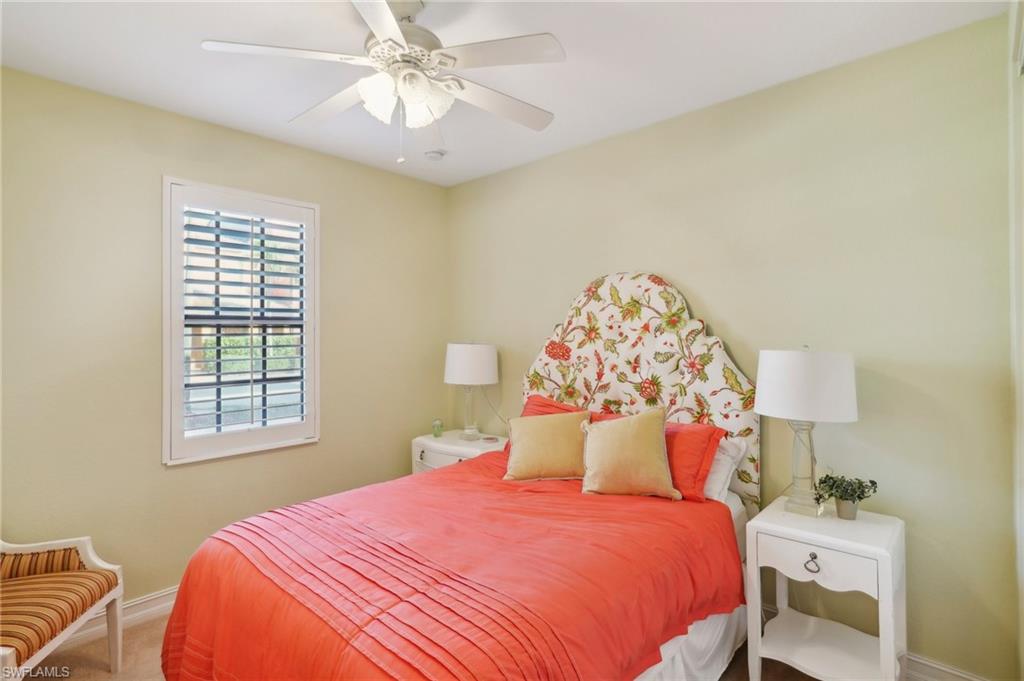 9108 Capistrano Street South, Unit 7401 Naples, FL 34113 - Photo 28 of 44 a bedroom with a bed and a chandelier