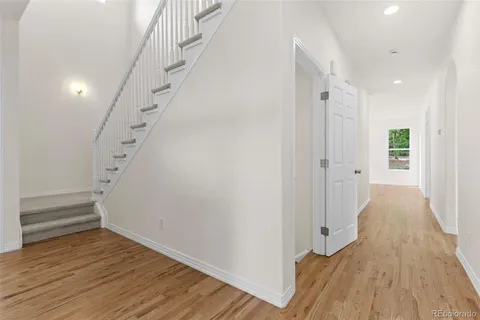 a view of a hallway with wooden floor and entryway