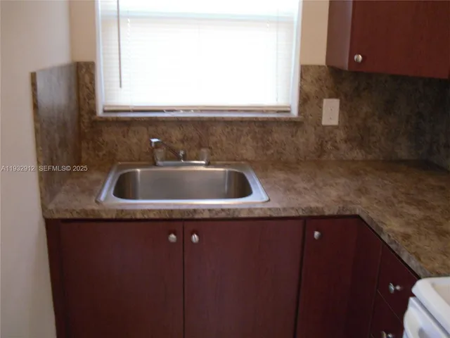 a kitchen with a sink a stove and cabinets