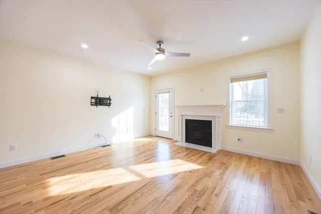 a view of empty room with wooden floor and fireplace
