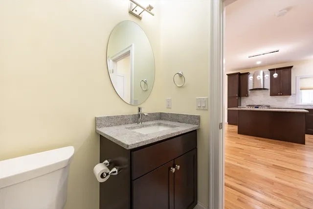 a bathroom with a granite countertop sink a toilet and a mirror
