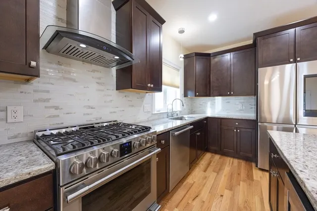a kitchen with granite countertop a sink stainless steel appliances and cabinets