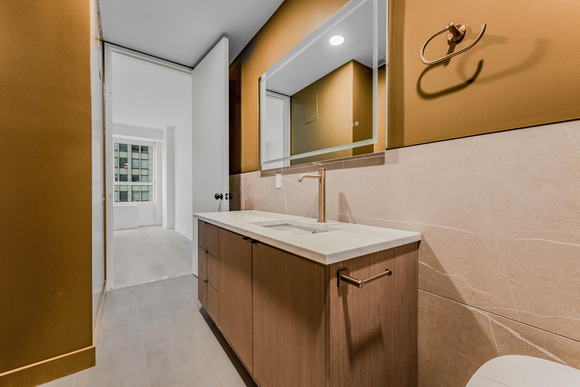 146 West 57th Street, Unit 52E Manhattan, NY 10019 - Photo 14 of 19 a bathroom with a sink and a mirror