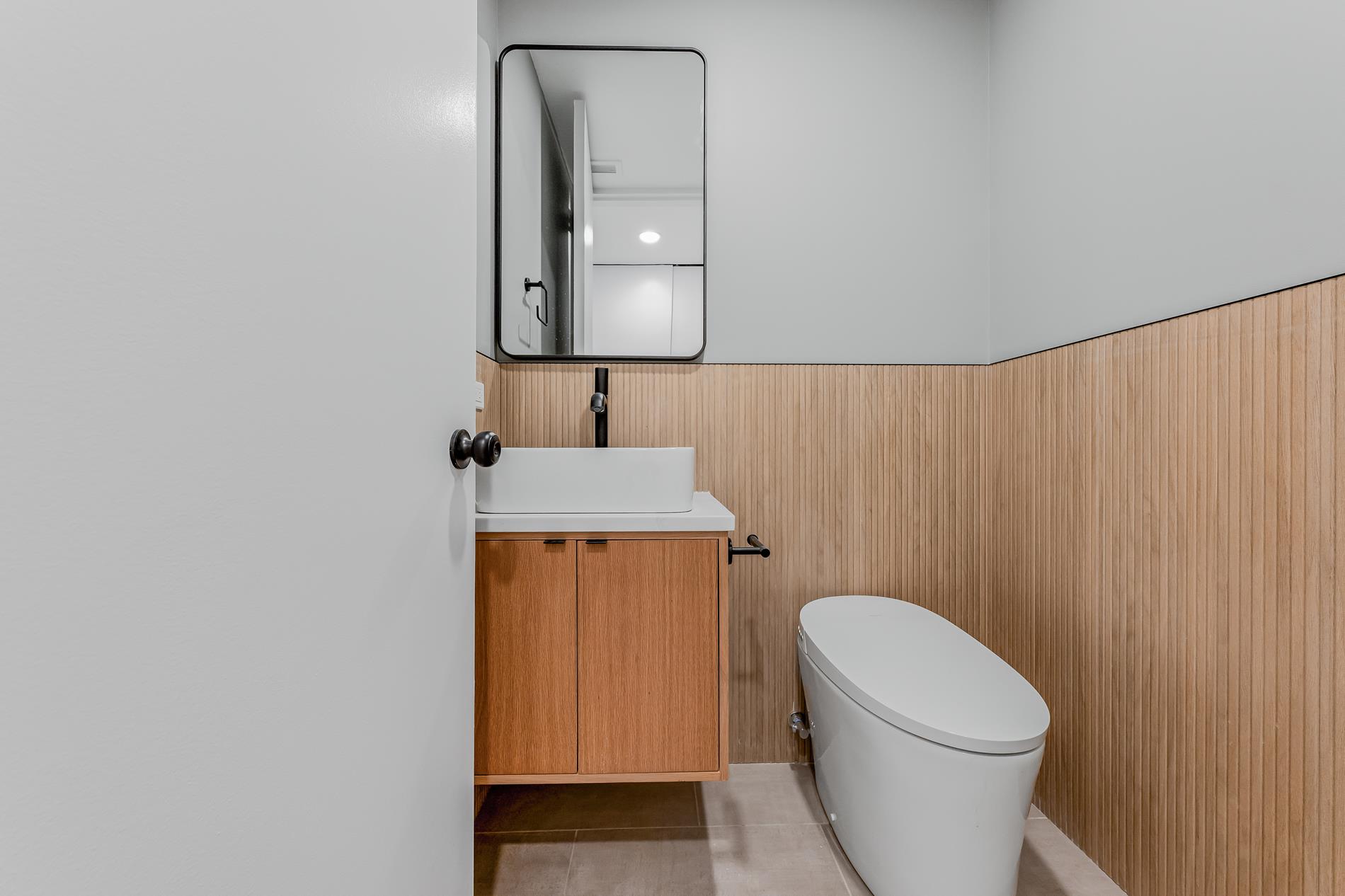 146 West 57th Street, Unit 52E Manhattan, NY 10019 - Photo 7 of 19 a bathroom with a toilet a sink and mirror
