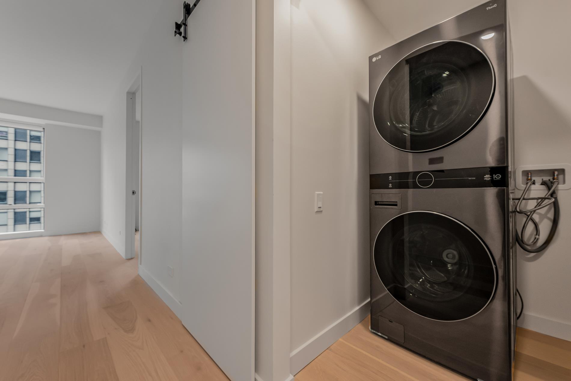 146 West 57th Street, Unit 52E Manhattan, NY 10019 - Photo 9 of 19 a view of a hallway with washer and dryer