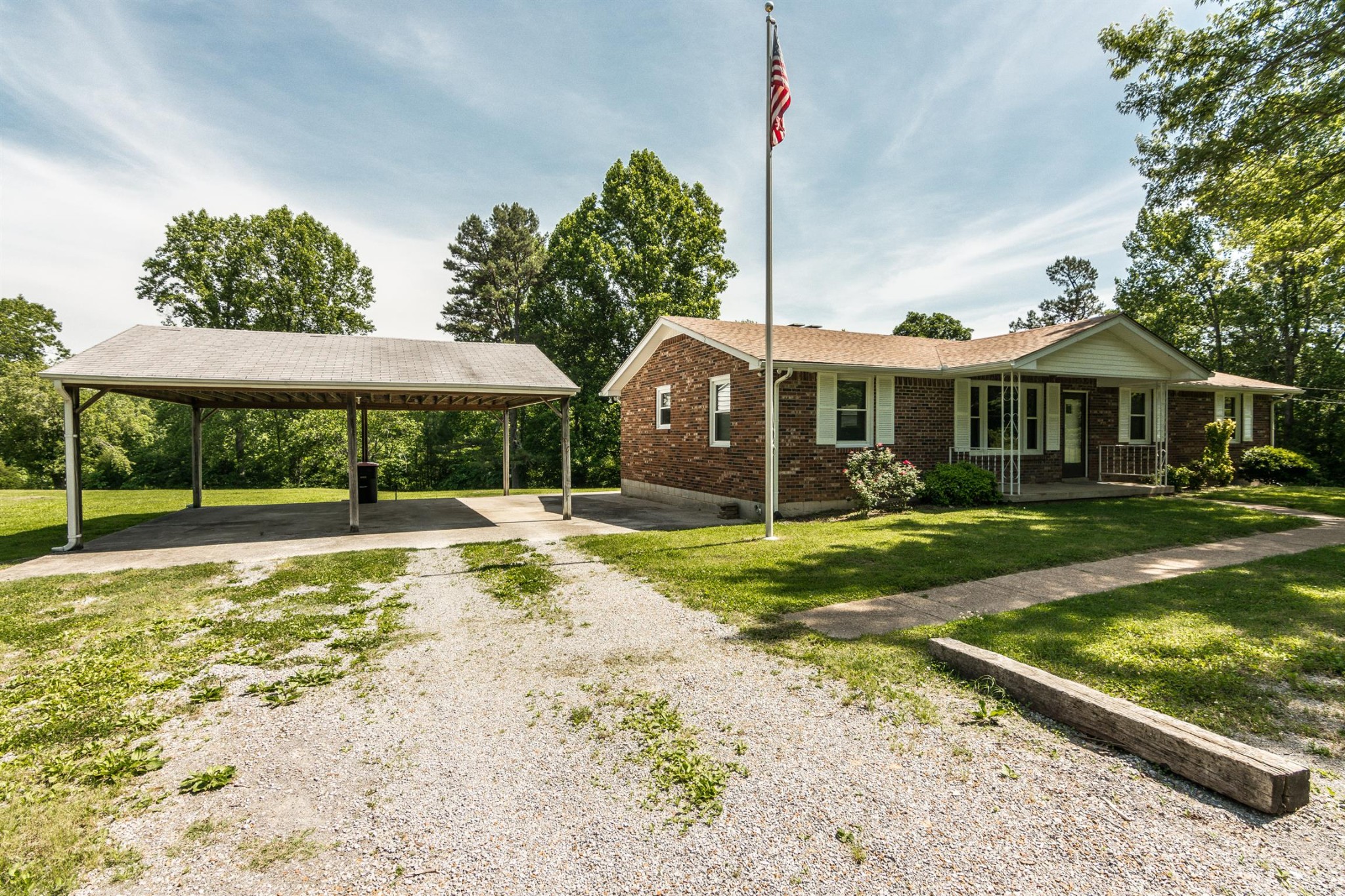 5124 Ridge Hill Road Joelton, TN 37080 - Photo 2 of 27 a view of a white house with a yard table and chairs under an umbrella