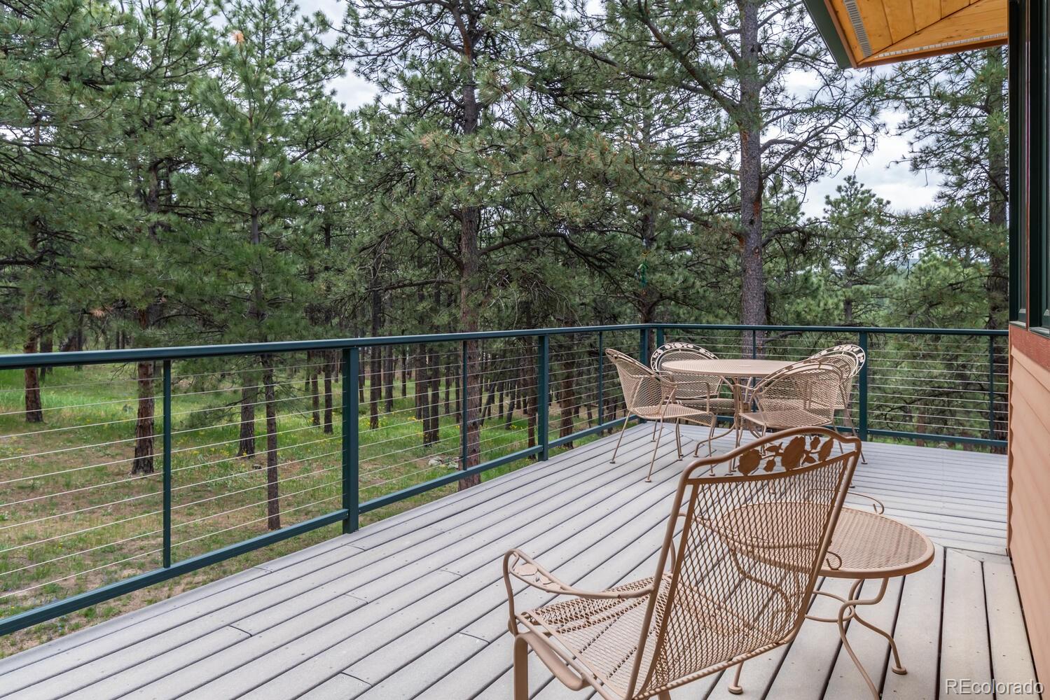 498 Mountain Meadows Road Boulder, CO 80302 - Photo 32 of 40 a view of a roof deck with table and chairs with wooden floor and fence