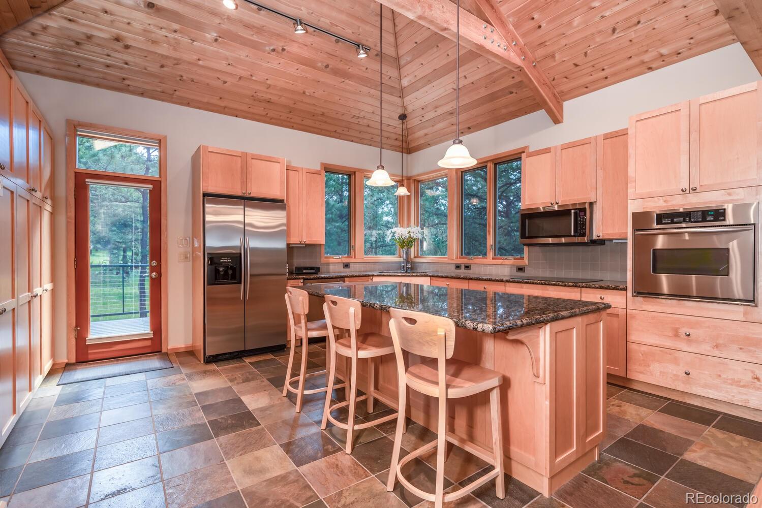498 Mountain Meadows Road Boulder, CO 80302 - Photo 9 of 40 a kitchen with stainless steel appliances granite countertop a stove a refrigerator a oven with white cabinets and glass windows