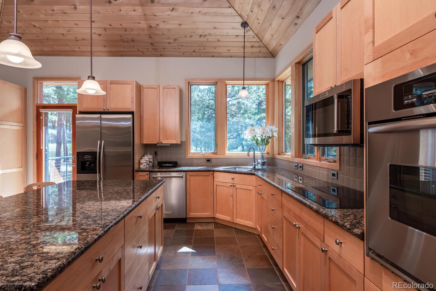 498 Mountain Meadows Road Boulder, CO 80302 - Photo 10 of 40 a kitchen with stainless steel appliances granite countertop a sink a stove and a wooden floors