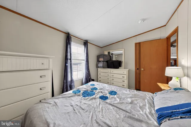 a bedroom with a large bed and a flat tv screen