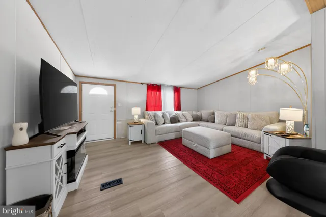 a living room with furniture flat screen tv and a lamp