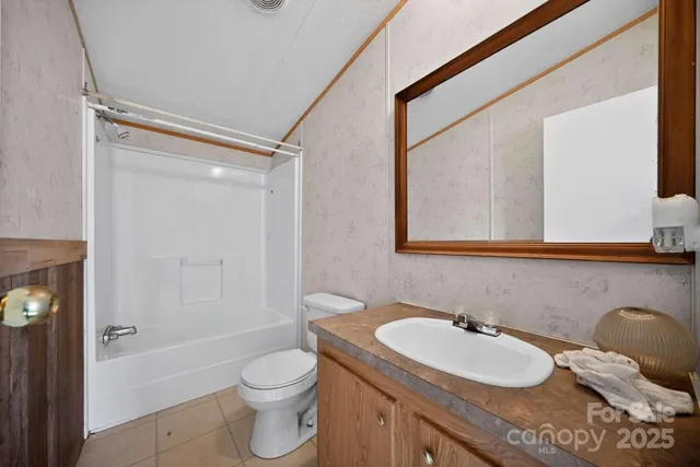 a bathroom with a granite countertop sink toilet a mirror and shower
