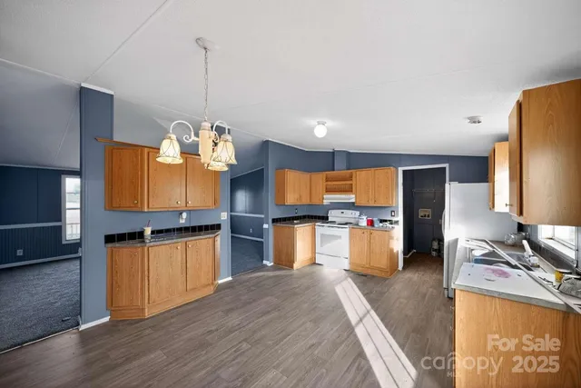 a kitchen with stainless steel appliances wooden floor sink stove and refrigerator