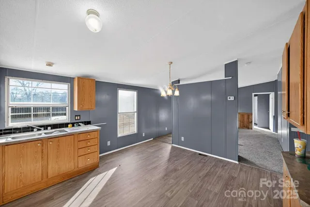 a kitchen with stainless steel appliances granite countertop a sink a stove and a wooden floors