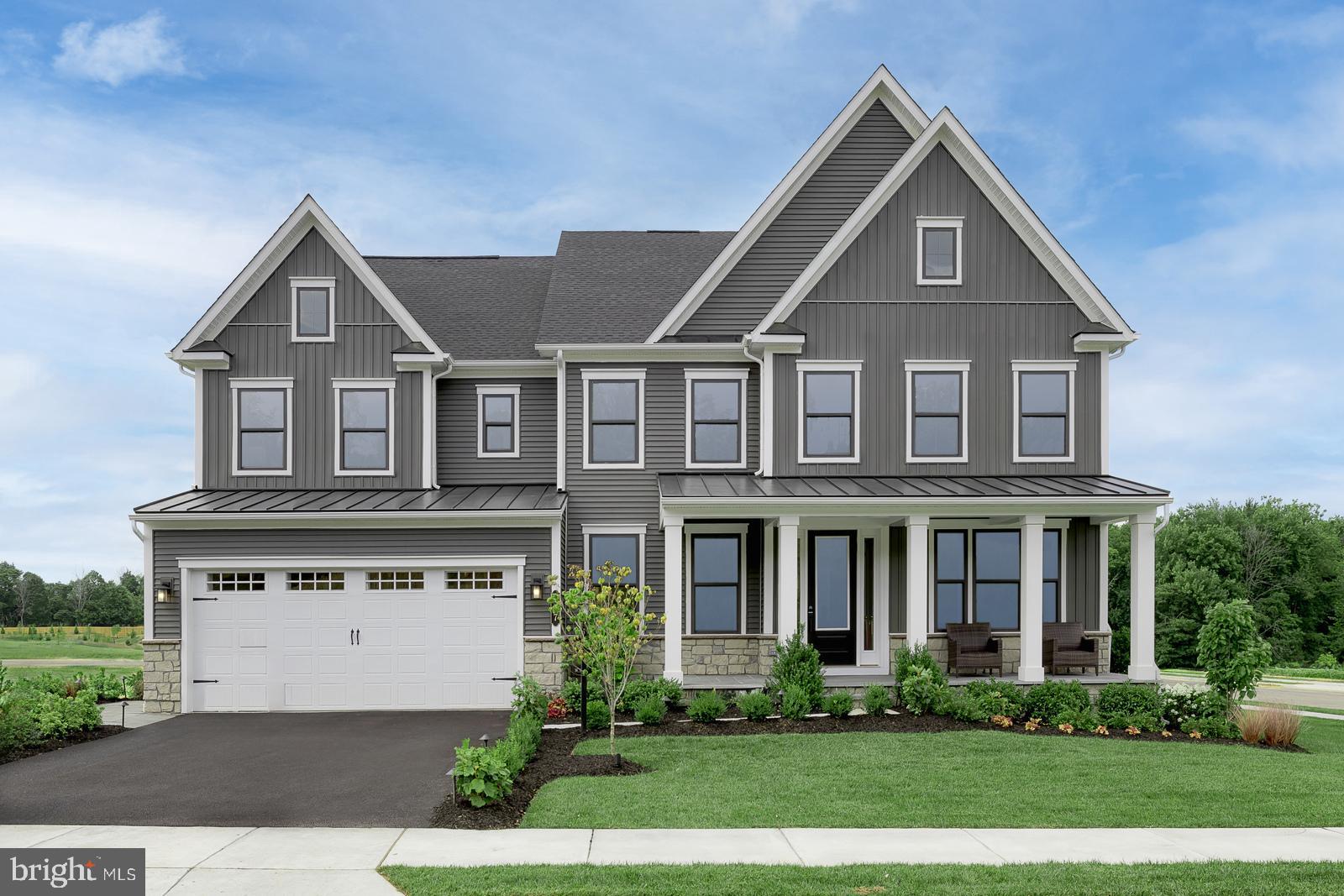 a front view of a house with a yard and plants