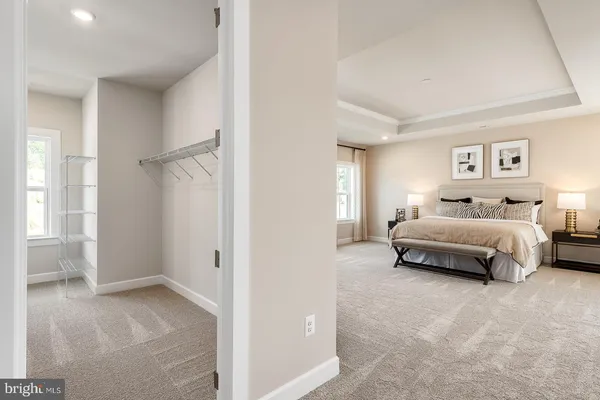 a spacious bedroom with a bed and glass windows