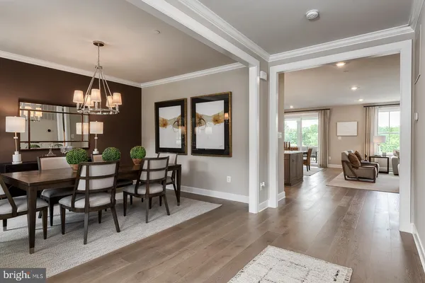 a view of a dining room and livingroom with furniture wooden floor a chandelier