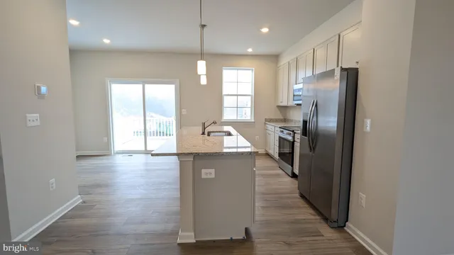 a kitchen with stainless steel appliances granite countertop a refrigerator a sink and a stove