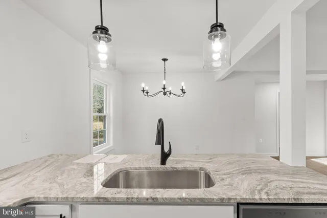 a kitchen with a sink granite counter tops and a wooden floor
