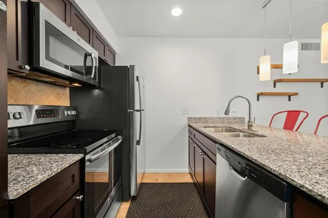 a kitchen with stainless steel appliances granite countertop a sink stove and refrigerator