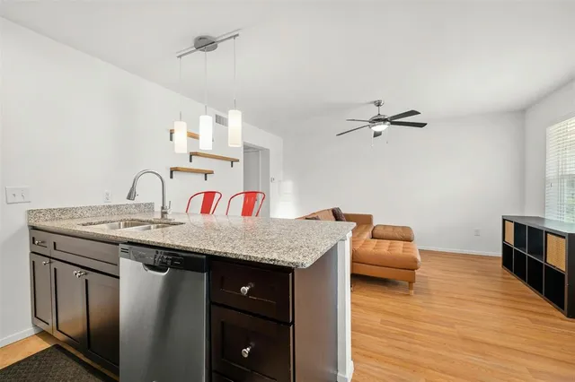 a utility room with a sink dryer and wooden floor
