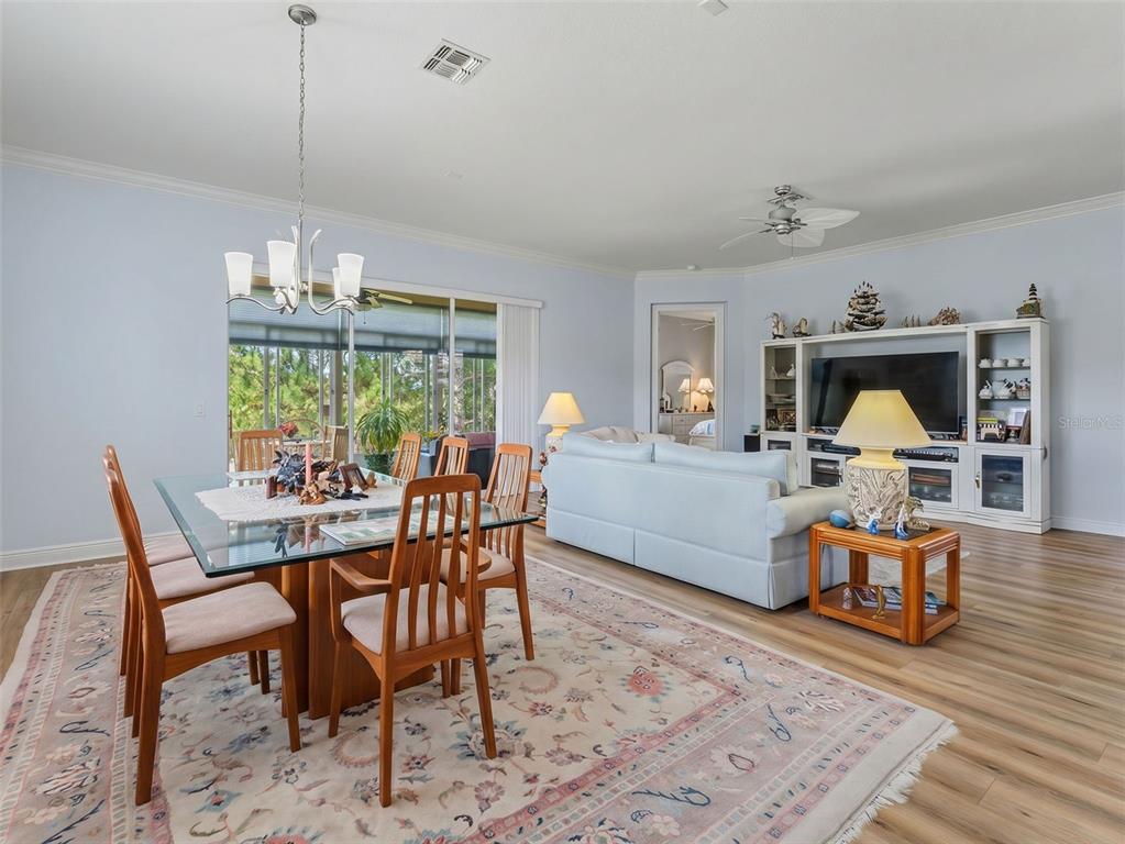 8910 Jericho Road Weeki Wachee, FL 34613 - Photo 21 of 52 a dining room with furniture a chandelier and wooden floor