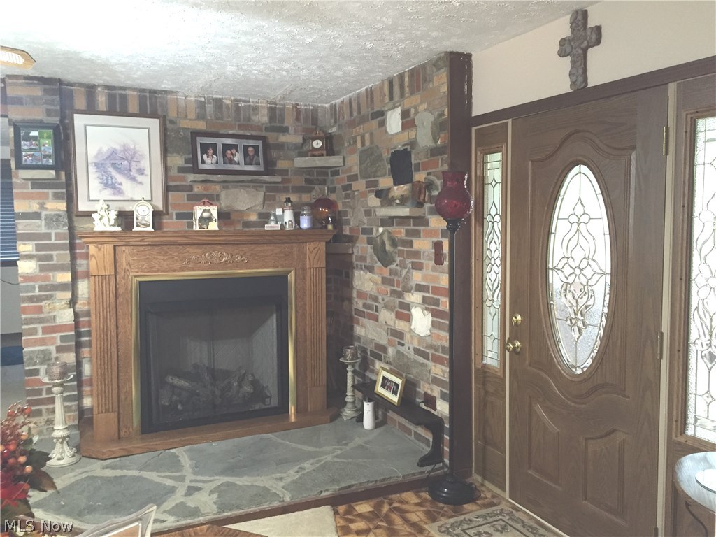 6474 Carsten Road Medina, OH 44256 - Photo 4 of 25 This beautiful gas fireplace is surrounded by a brick accent wall and really adds a cozy feeling to the room on cool days and nights. The attractive front door leads out onto the front porch and lets in the morning light.
