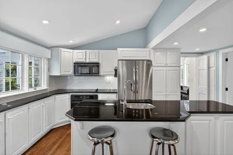a kitchen with stainless steel appliances granite countertop a sink and a refrigerator