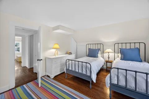 a bedroom with two beds and painting on the wall