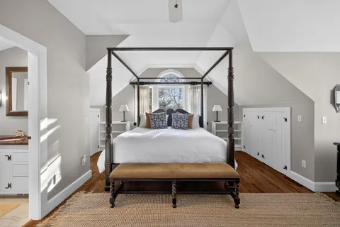 a bedroom with a bed window and a table in it