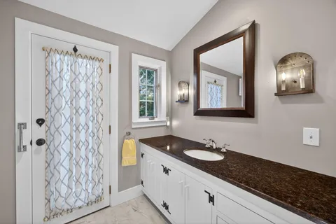 a bathroom with a granite countertop sink and a mirror