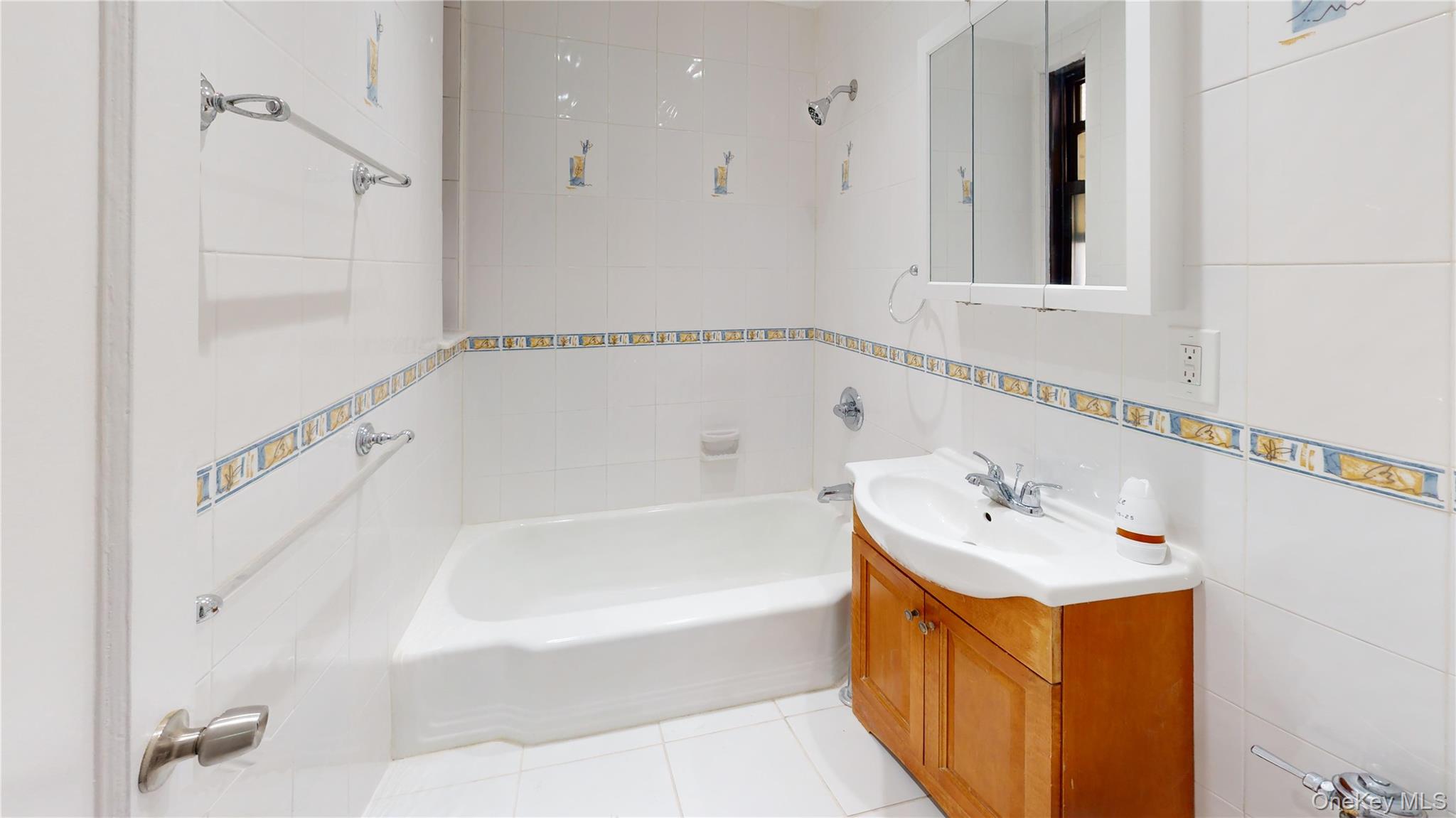 112-30 Northern Boulevard, Unit 4B Queens, NY 11368 - Photo 11 of 12 Full bath featuring tile walls, vanity, light tile patterned floors, and bathing tub / shower combination