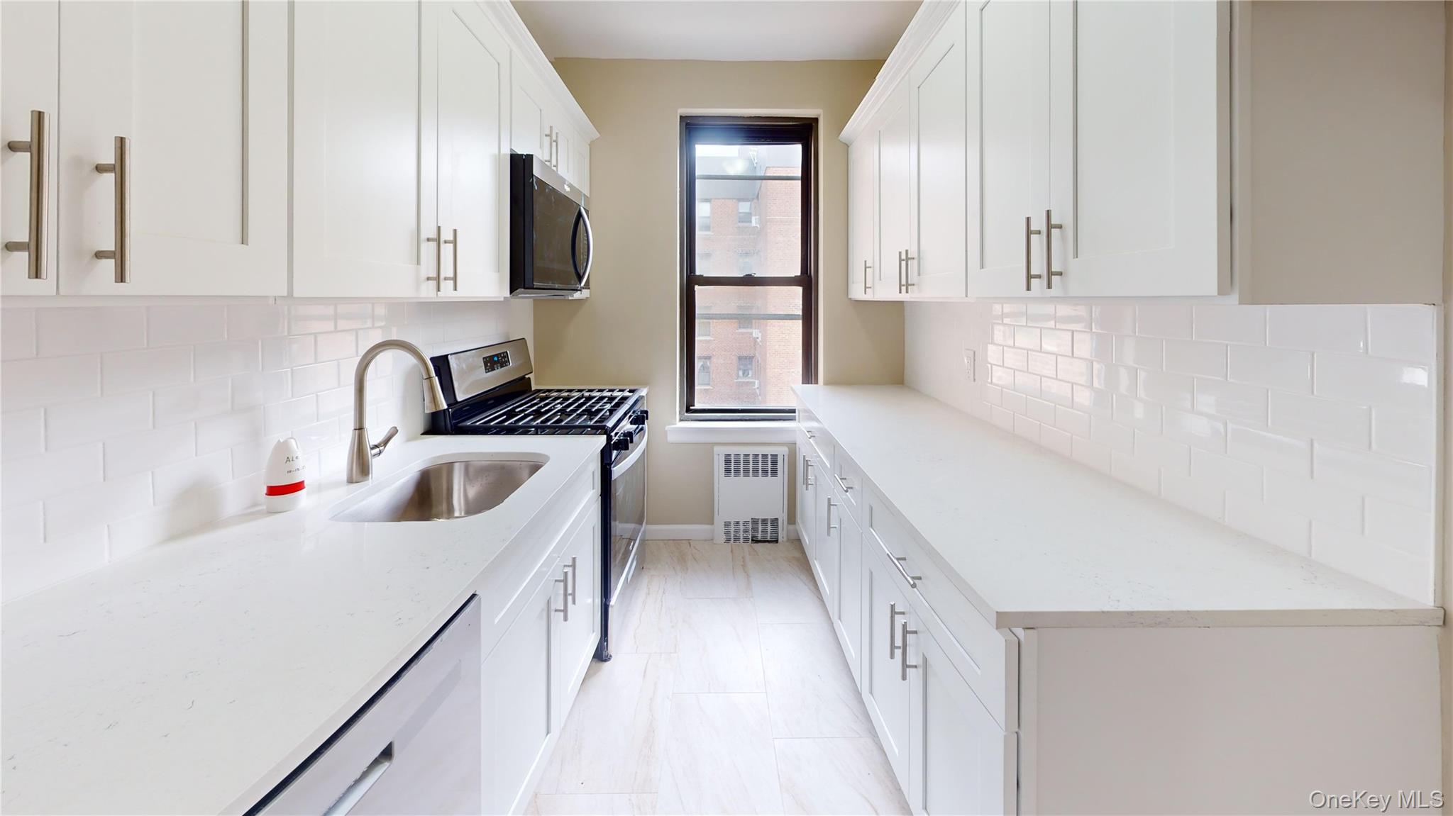 112-30 Northern Boulevard, Unit 4B Queens, NY 11368 - Photo 4 of 12 Kitchen featuring appliances with stainless steel finishes, backsplash, and white cabinets