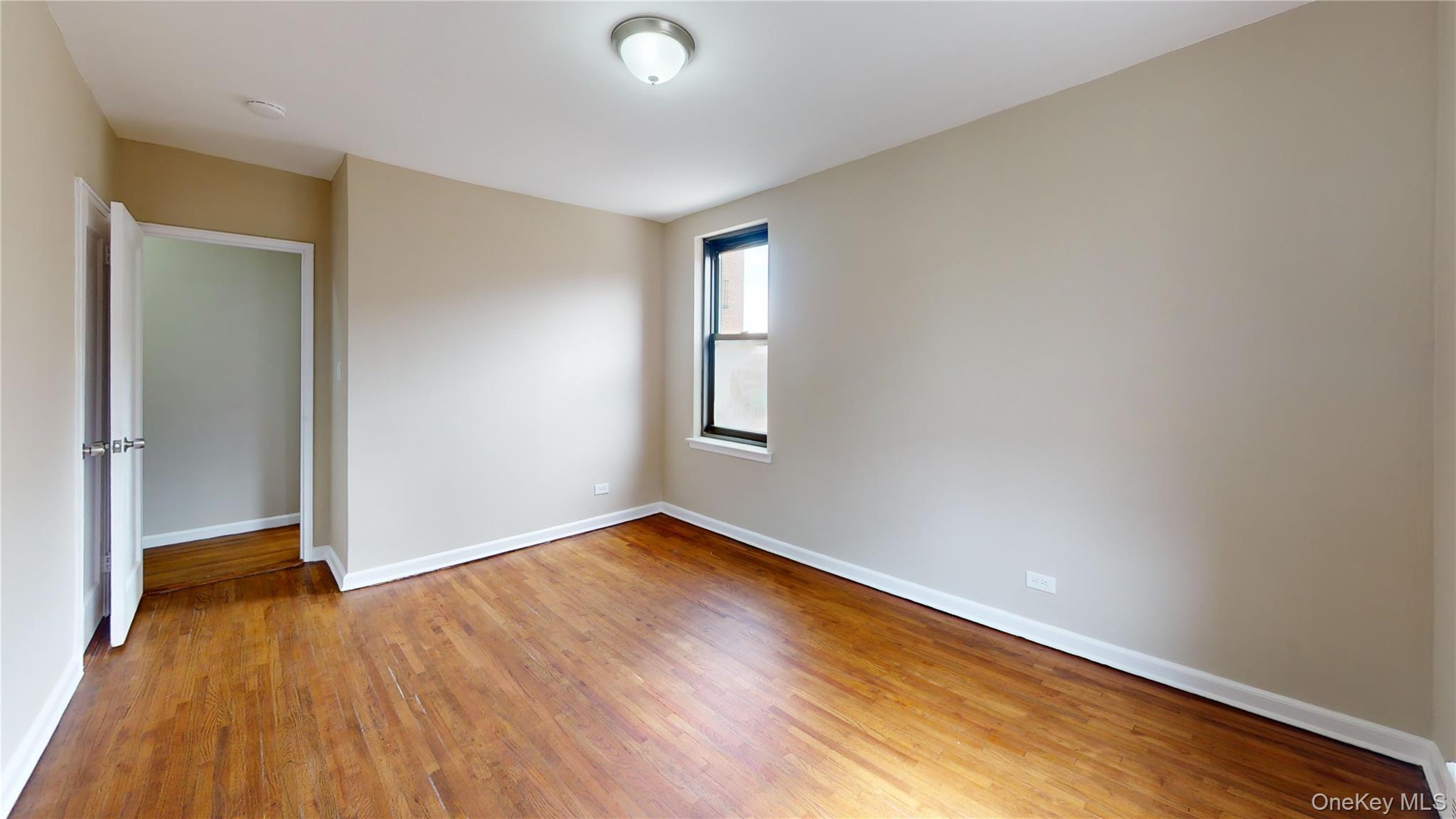 112-30 Northern Boulevard, Unit 4B Queens, NY 11368 - Photo 9 of 12 Unfurnished room featuring baseboards and light wood finished floors
