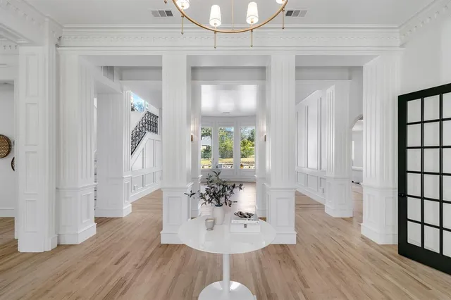 a dining room with wooden floor table and chairs