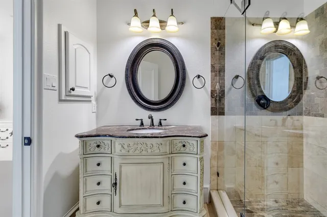 a bathroom with a sink vanity mirror and tub