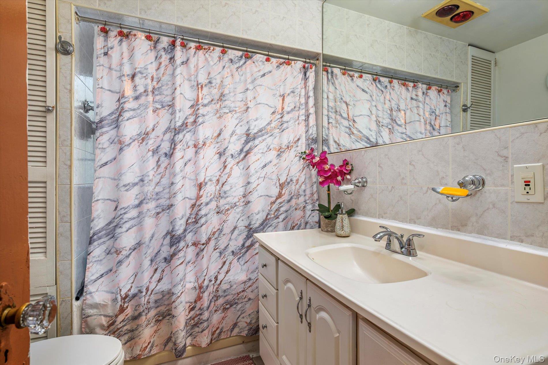 133-15 231st Street Queens, NY 11413 - Photo 12 of 22 a bathroom with a sink and a mirror