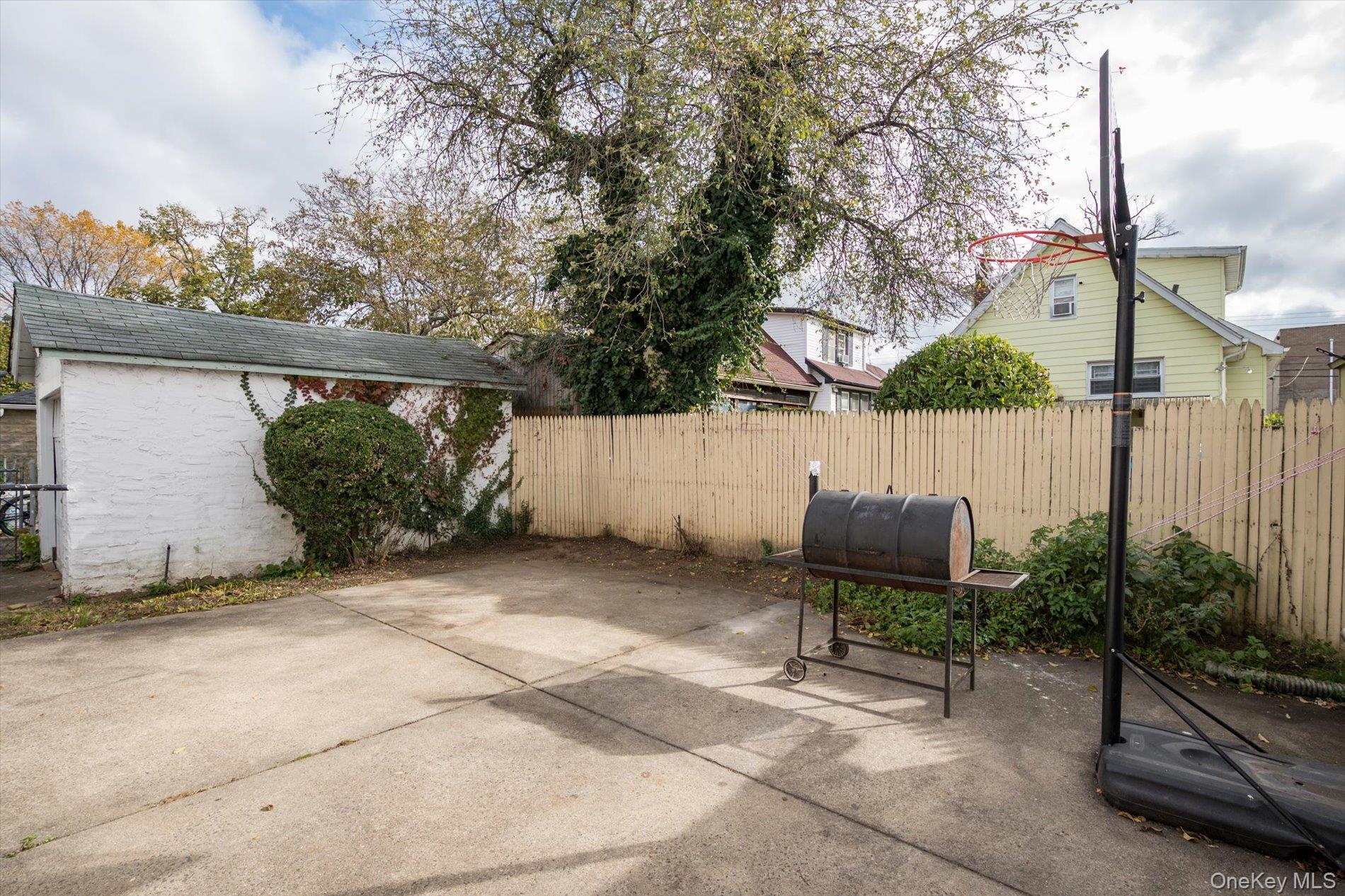 133-15 231st Street Queens, NY 11413 - Photo 21 of 22 a backyard of a house with chairs and a fence
