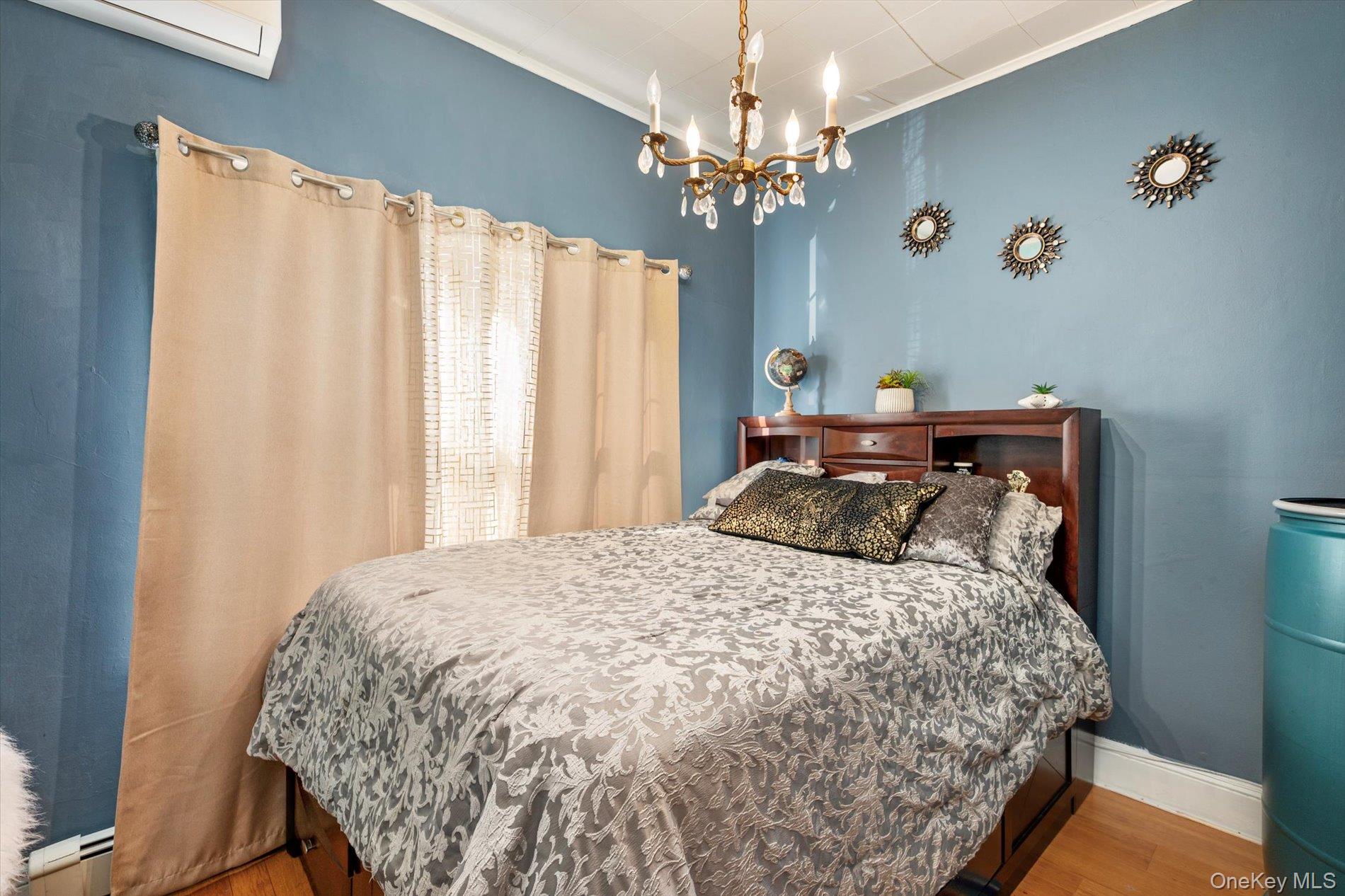 133-15 231st Street Queens, NY 11413 - Photo 9 of 22 a bedroom with a bed and a chandelier