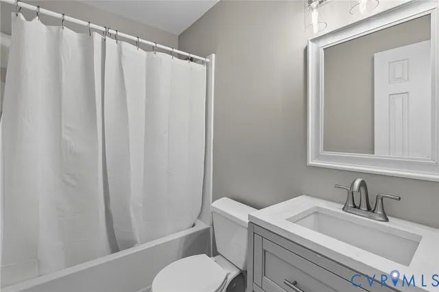 a bathroom with a sink vanity mirror and toilet