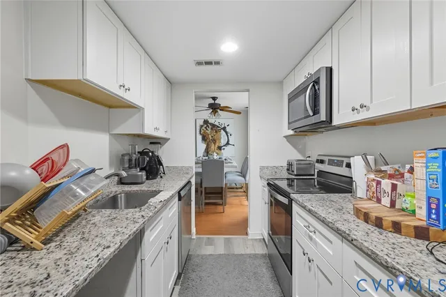 a kitchen with stainless steel appliances granite countertop a stove and a sink