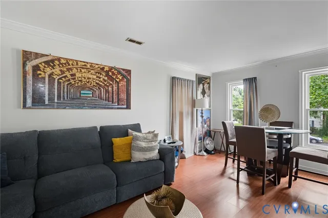 a living room with furniture a dining table and a window