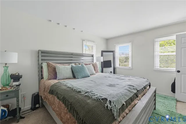 a bedroom with a bed and a potted plant on table