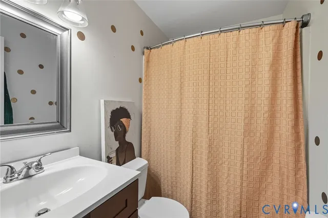 a bathroom with a sink mirror and a toilet