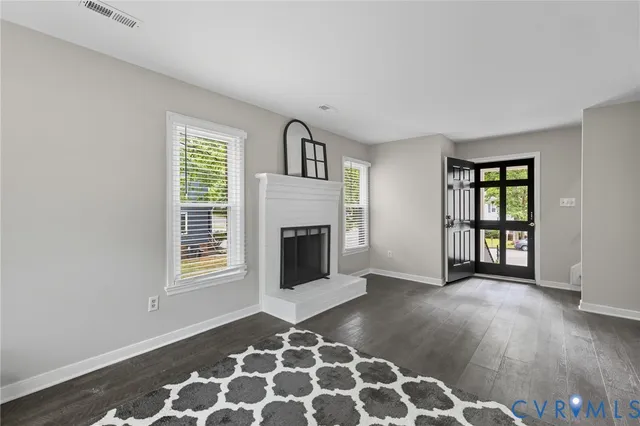 a view of an empty room with a fireplace and a window