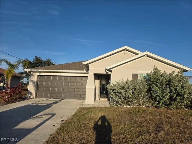 a view of a house with backyard and parking