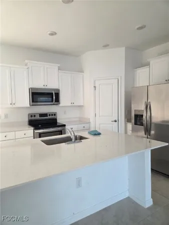 a kitchen with kitchen island a sink stainless steel appliances and cabinets
