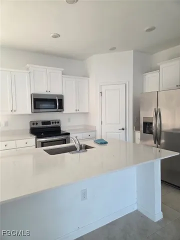 a kitchen with kitchen island a sink stainless steel appliances and cabinets