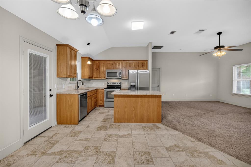 505 East 5th Street Springtown, TX 76082 - Photo 8 of 39 a large kitchen with stainless steel appliances kitchen island granite countertop a stove a sink a refrigerator and a refrigerator