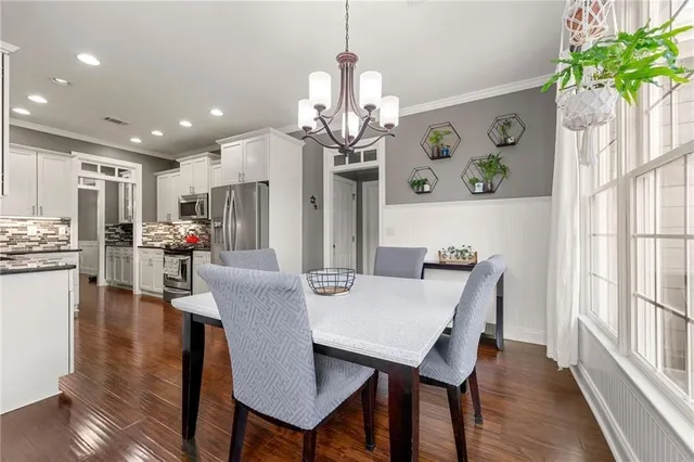a view of a dining room with furniture a chandelier and wooden floor